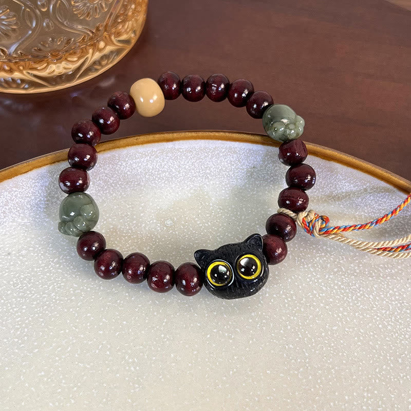 Pulsera de madera de ébano con borlas de la paz y pata de jade y gato encantador de Mythstone 