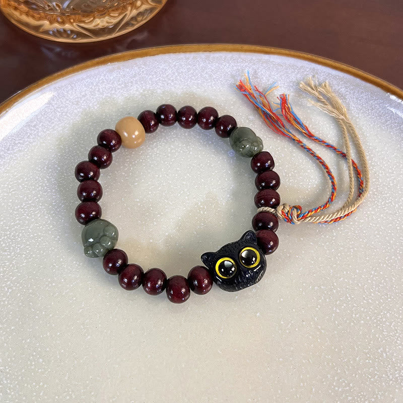 Pulsera de madera de ébano con borlas de la paz y pata de jade y gato encantador de Mythstone 