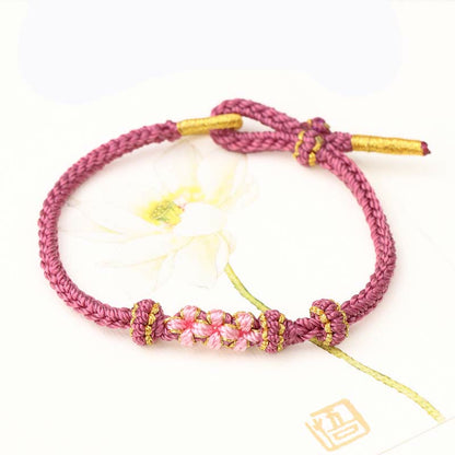 Pulsera trenzada de ocho hebras con tres flores de melocotón hecha a mano de Mythstone