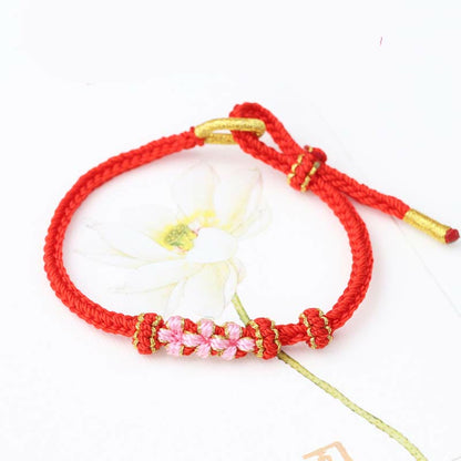 Pulsera trenzada de ocho hebras con tres flores de melocotón hecha a mano de Mythstone