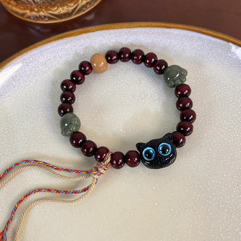 Pulsera de madera de ébano con borlas de la paz y pata de jade y gato encantador de Mythstone 