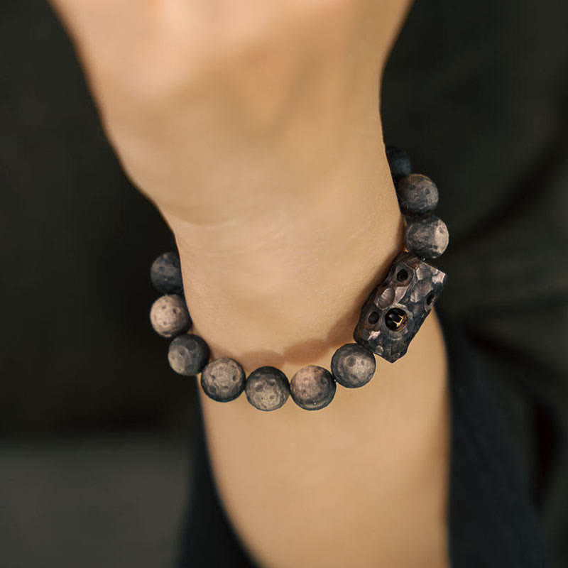 Pulsera relajante de madera de ébano y obsidiana con brillo plateado Mythstone 